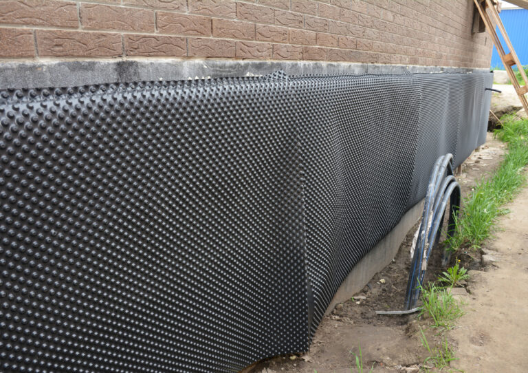 protecting-the-basement-foundation-outside-of-a-brick-house-from-water-and-moisture-using-a-foundation-waterproofing-dimpled-membrane-barrier-for-the-exterior-walls-house-foundation-waterproofing